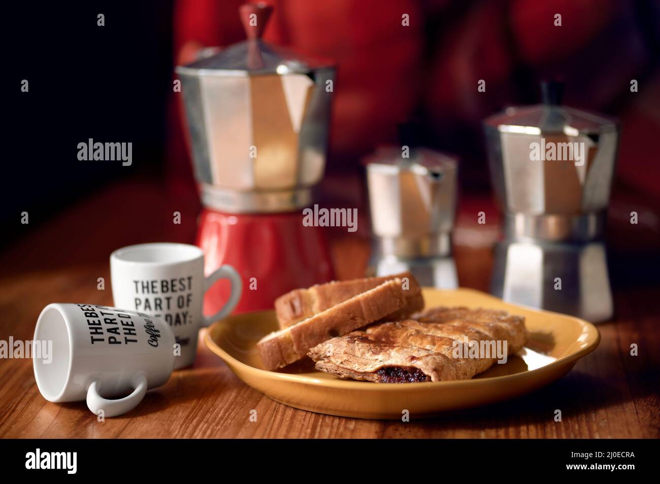 Italian coffee pots and pastries on a table with cups of coffee