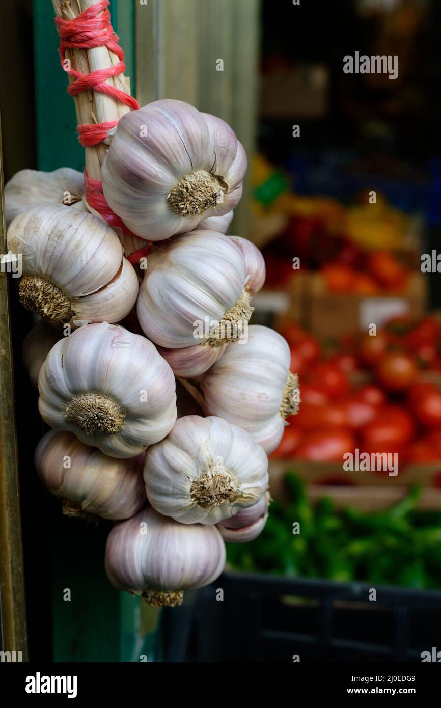 garlic bulbs hanging at the entrance to a fruit and vegetable store Stock Photo Alamy