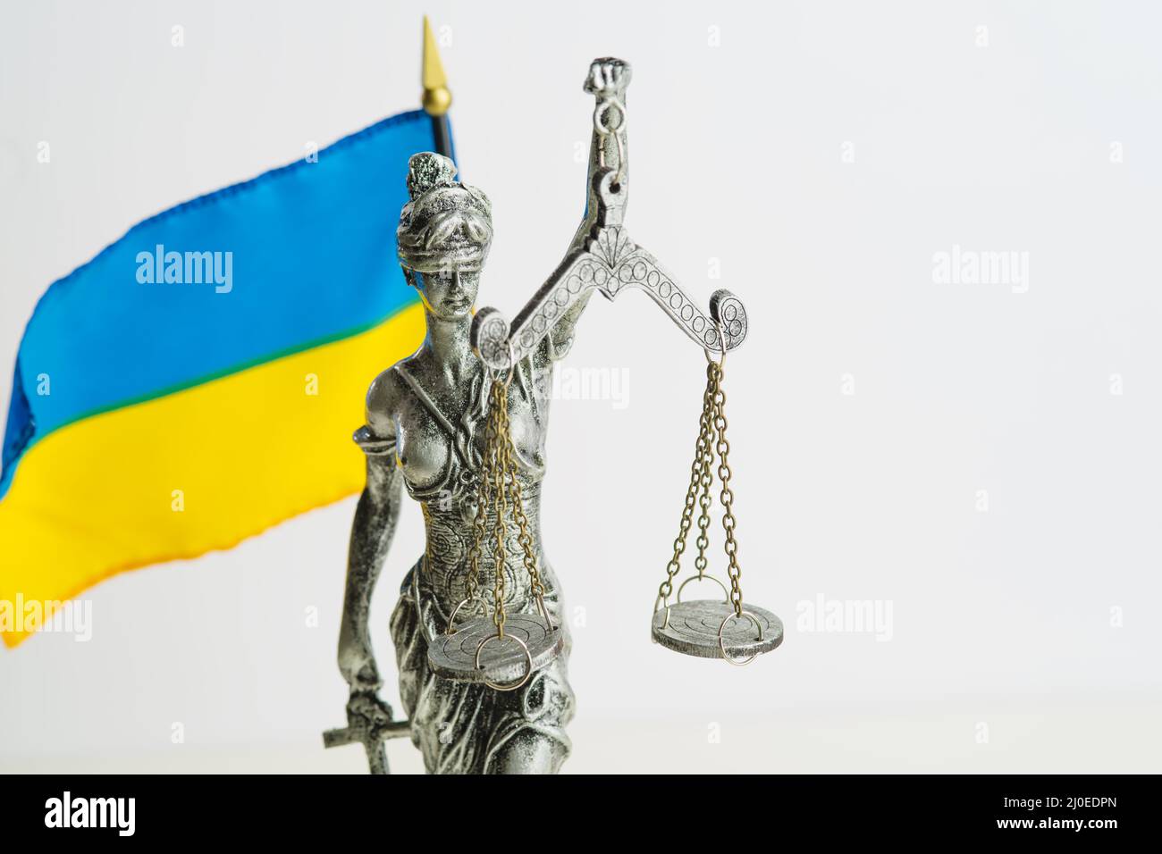 Statue of Themis - Goddess of Justice and the Ukrainian flag on a white background. Court system, Constitution, rule of law, protection of Ukraine fro Stock Photo