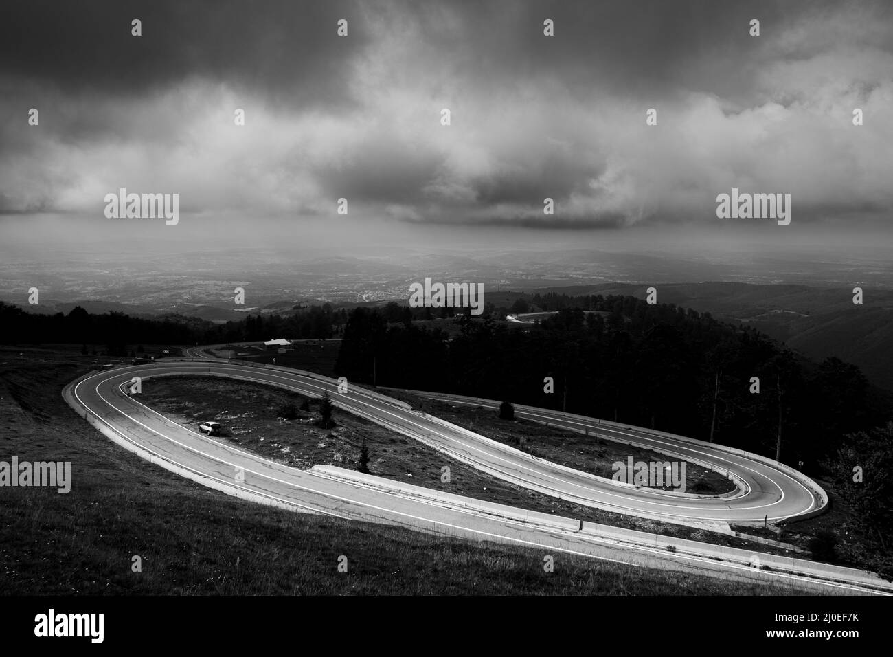 black and white winding road stormy weather in mountain of Romania ...