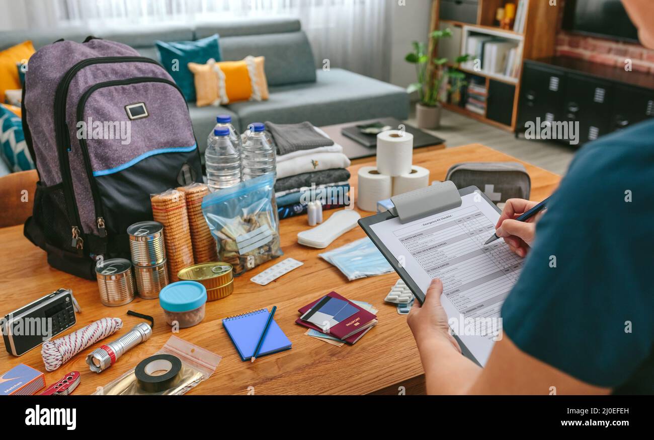 Woman doing checklist of emergency backpack Stock Photo Alamy