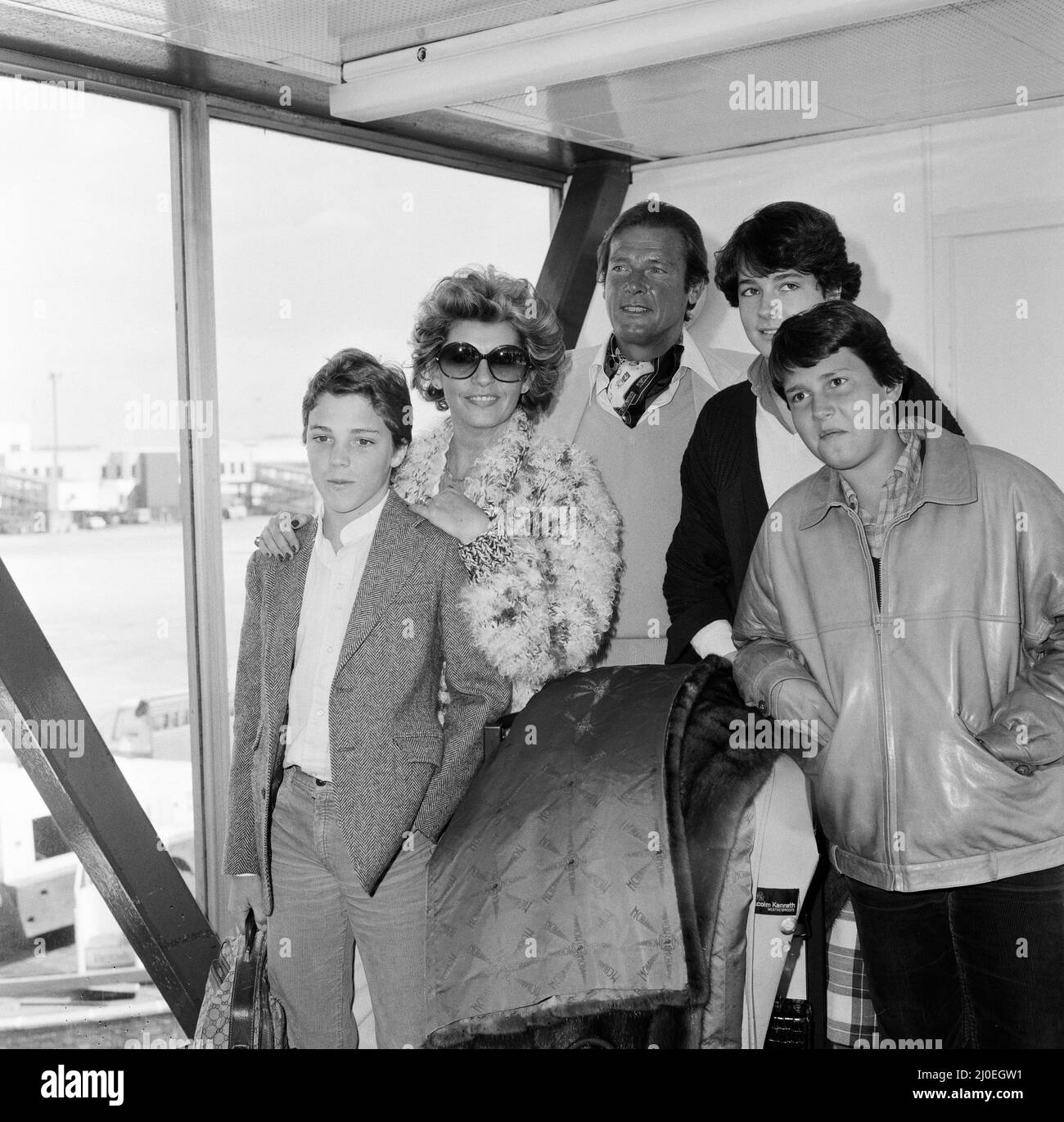 Roger Moore with his wife Luisa and family, daughter Deborah (16), son Geoffrey (14) and Sacha Newley (14, left of the picture). They have all arrived from Nice where they have been on holiday. Roger is here to promote his latest film 'North Sea Hijack.' 8th April 1980. Stock Photo