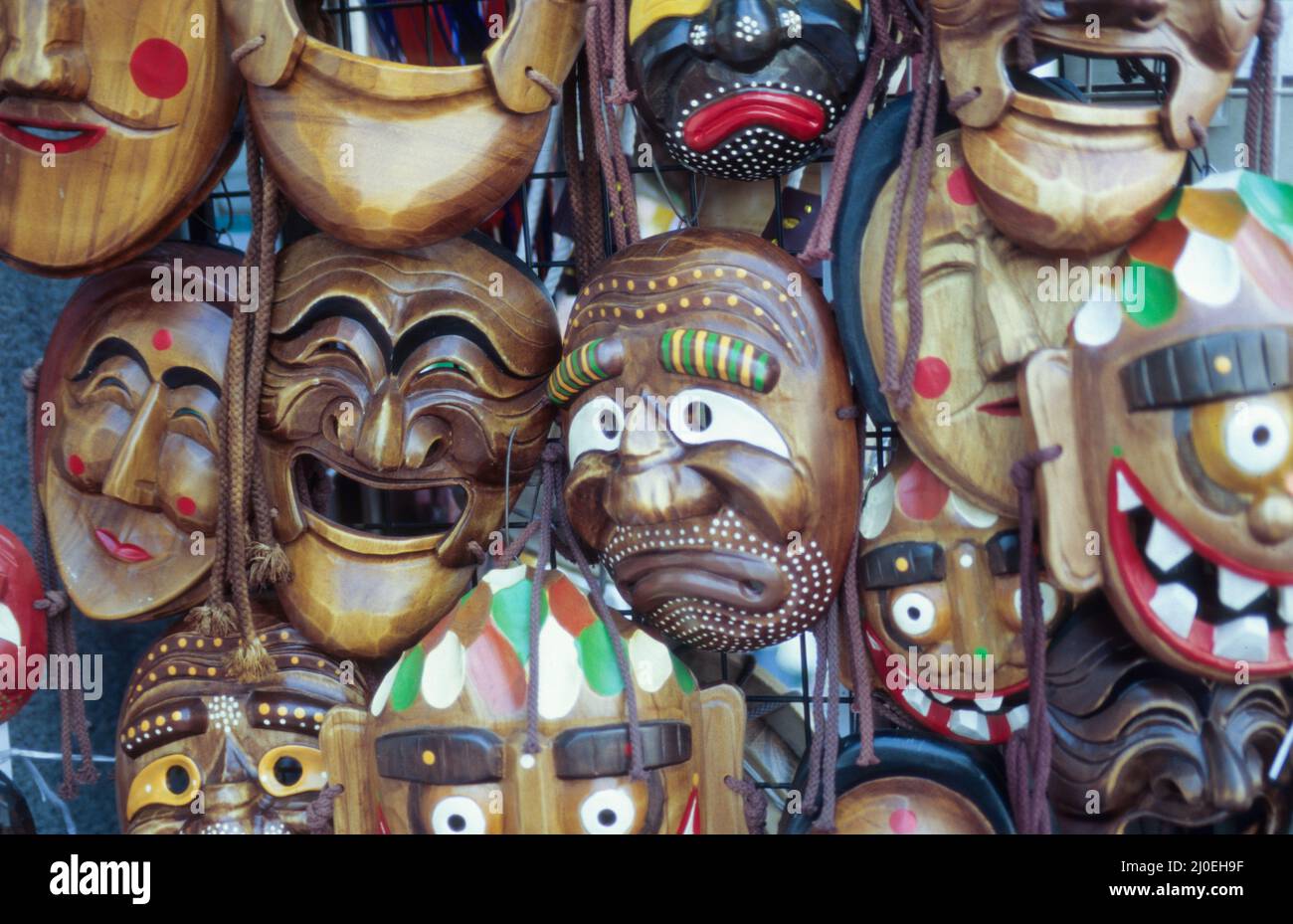 Stand mit Repliken traditioneller Holzmasken, wie sie in Korea bei bestimmten Festen getragen wurden - market stall with replicas of wooden masks that were traditionally worn at certain Korean events. Stock Photo