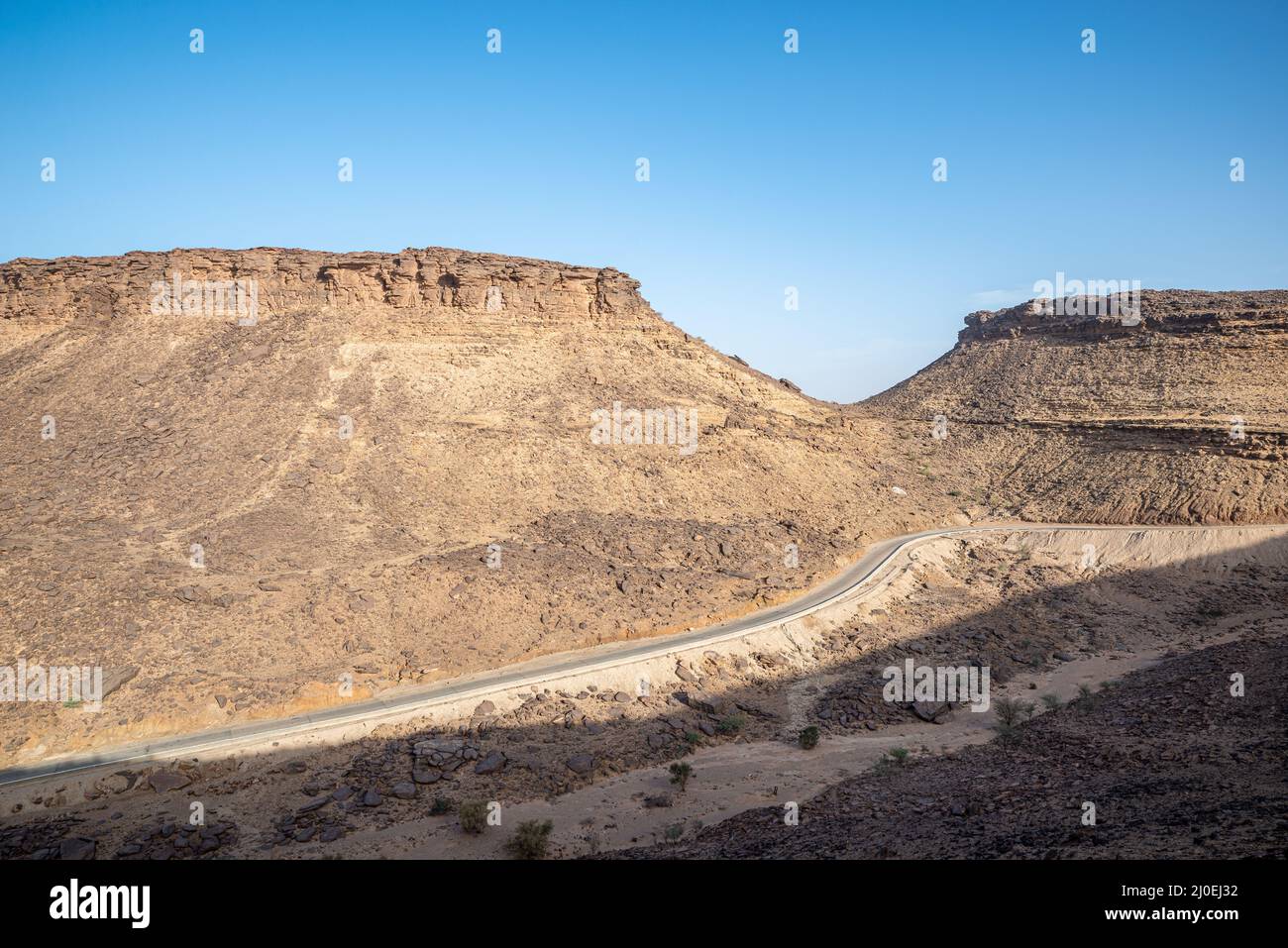 Road crossing a rocky landscape in Adrar Plateau region, Mauritania Stock Photo