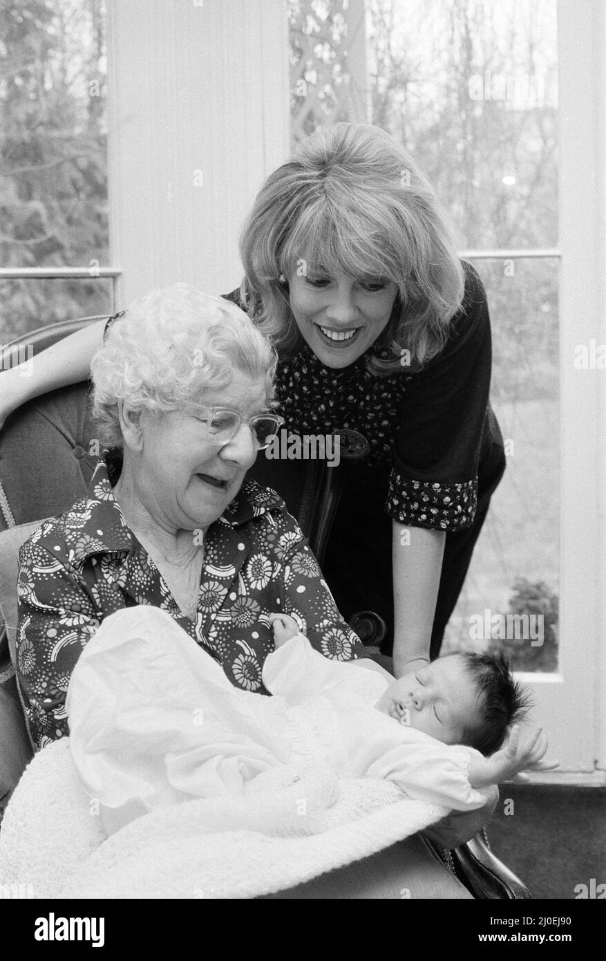 'That's Life' presenter Esther Rantzen presents her month old baby Emily to Annie Mizen today. Annie, 86, who became famous on That's Life by eating caviar and Chinese food, testing drinks and dancing in the street, was invited to elevenses at Esther's home and to meet Emily. 22nd February 1978. Stock Photo