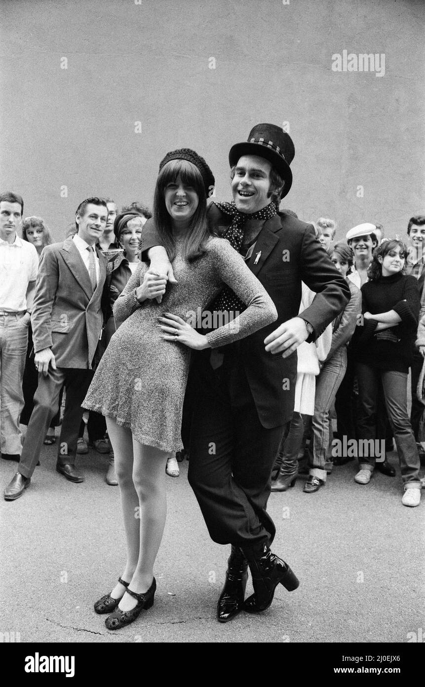 Wearing a top hat, Elton John, at a small studio in Ladbroke Grove to make a promotional film for his new single. Giving the film the feeling of the 1960's in the style of 'Ready Steady Go', Elton invited Cathy McGowan to take part. 5th October 1978. Stock Photo