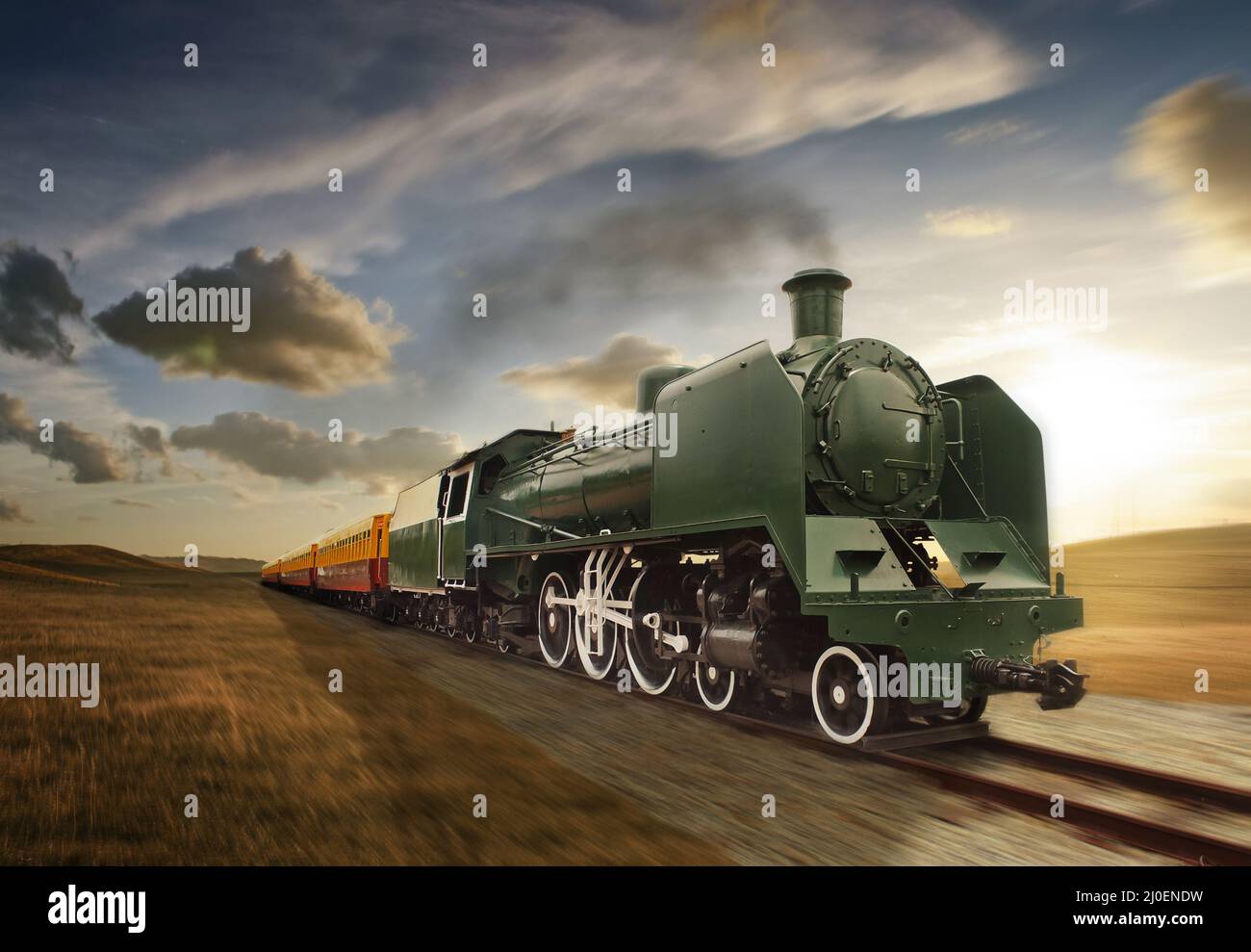 Vintage green and yellow steam powered railway train moving Stock Photo