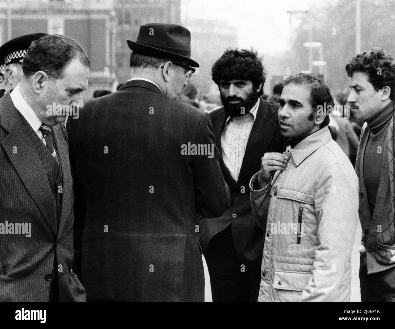 Third day of the Iranian Embassy Siege in London where six gunmen of the Iranian extremist group 'Democratic Revolutionary Movement for the Liberation of Arabistan' stormed the building, taking 26 hostages before the SAS retook the embassy and freed the hostages. The Iranian Consul General (wearing light coat) talking with police officers outside the Embassy building. 2nd May 1980. Stock Photo