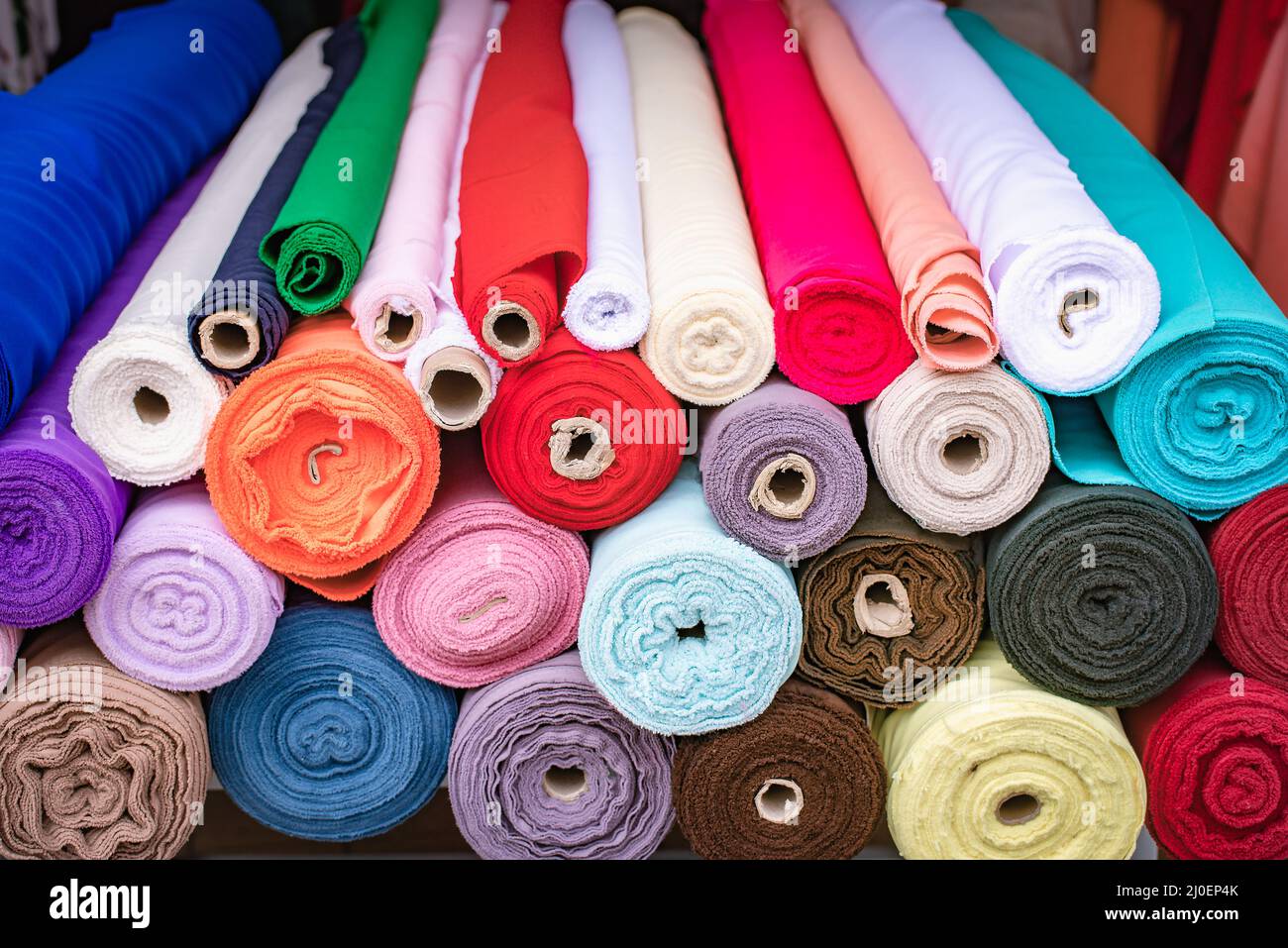 Colorful fabric rolls piled at the store Stock Photo