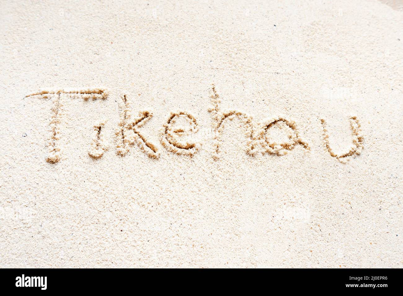 Handwriting words 'Tikehau' on sand of beach Stock Photo