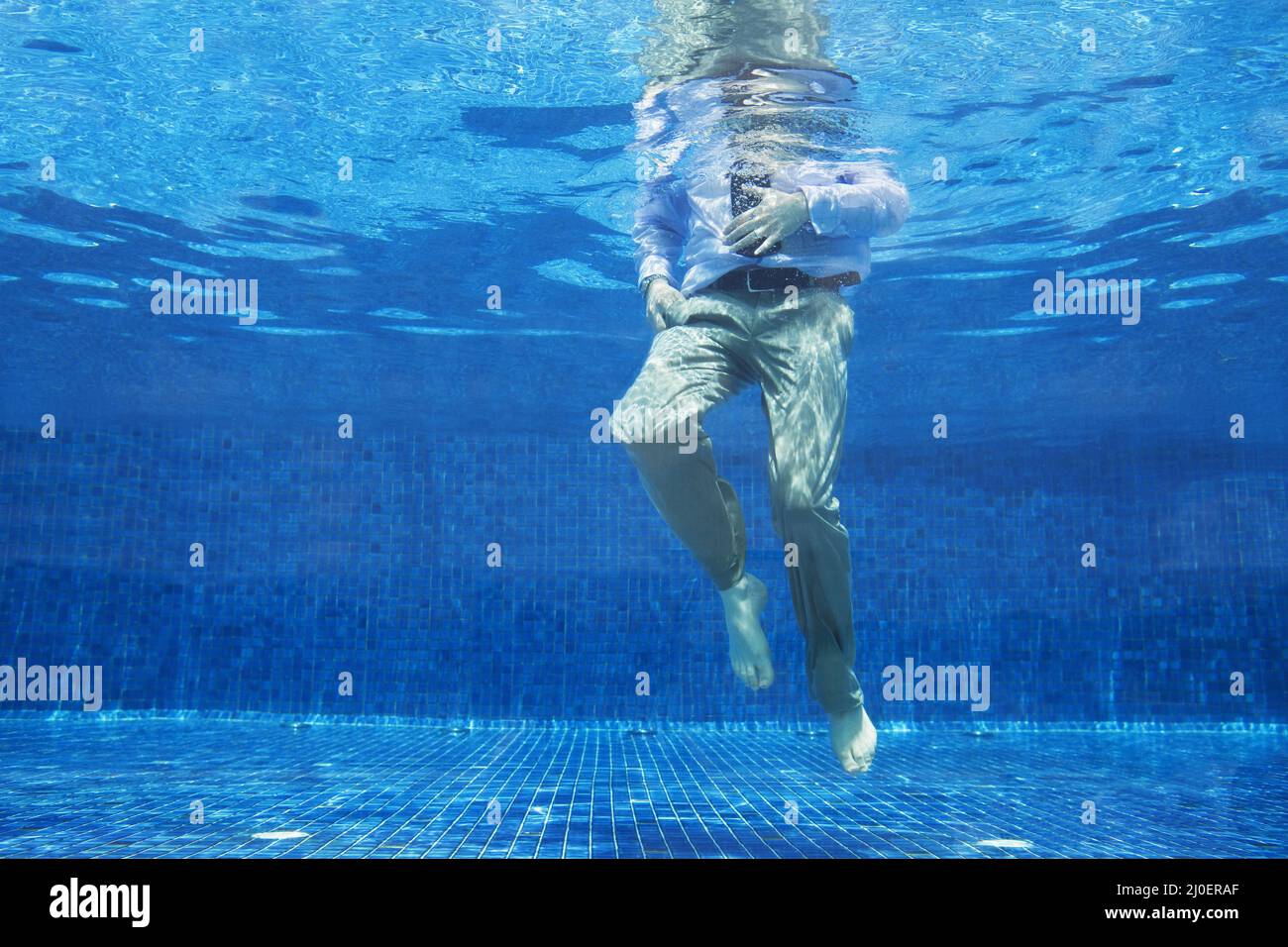 Low angle of businessman's legs underwater Stock Photo