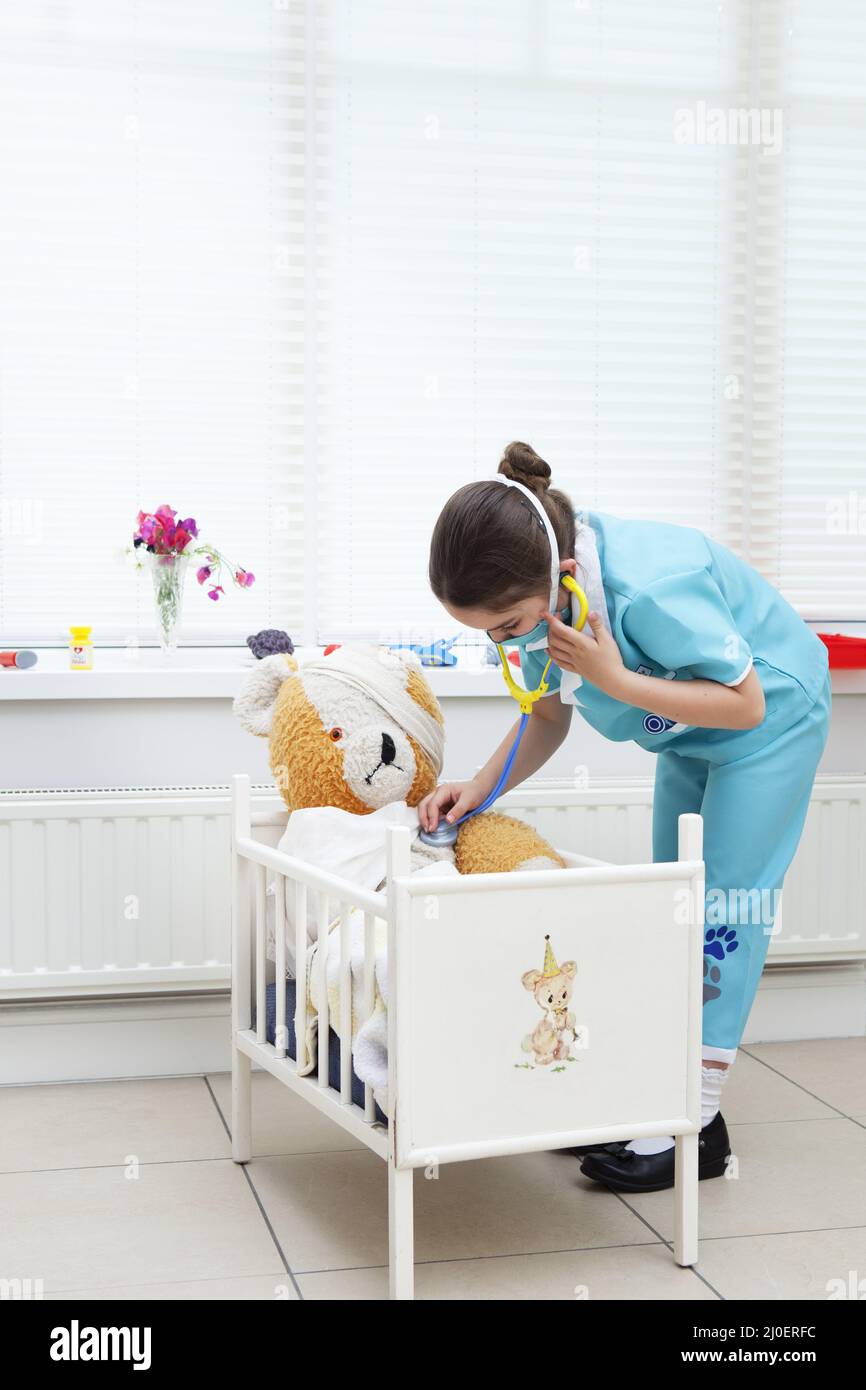 Caucasian girl nursing her teddy bear Stock Photo