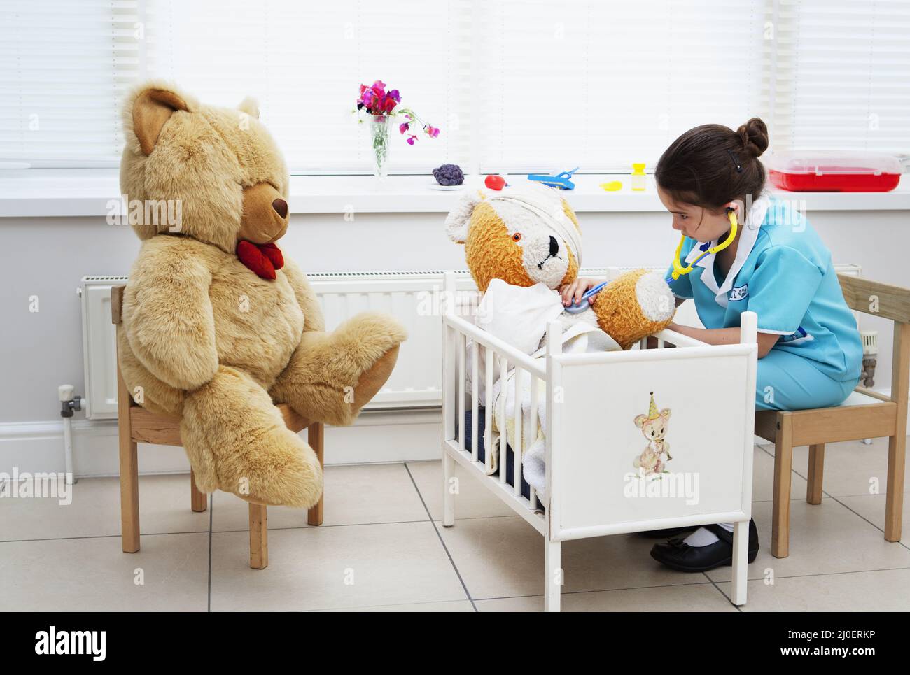 Caucasian girl nursing her teddy bear themes of daydreaming imagination ambition Stock Photo