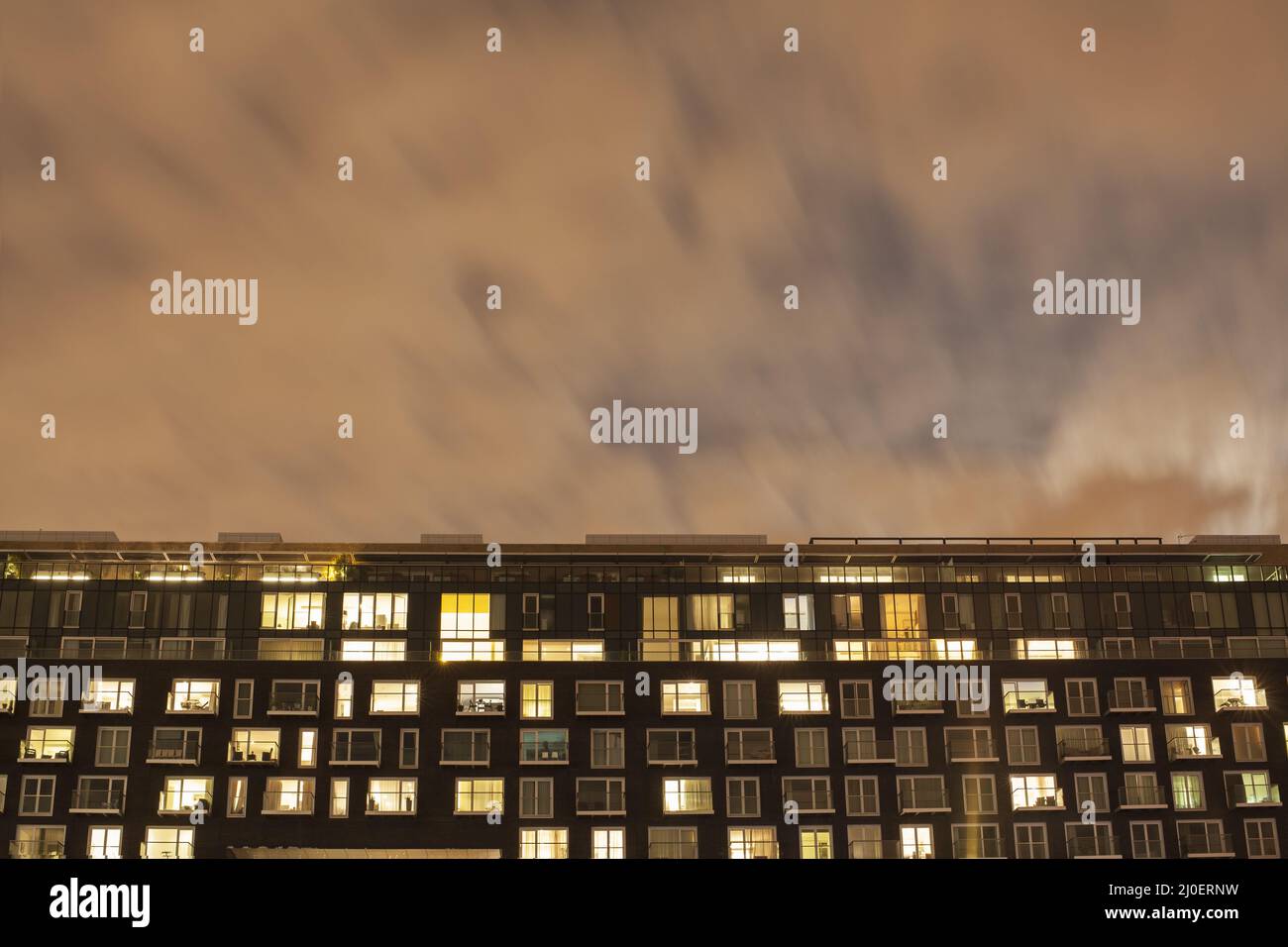The exterior of a modern apartment building at night Stock Photo