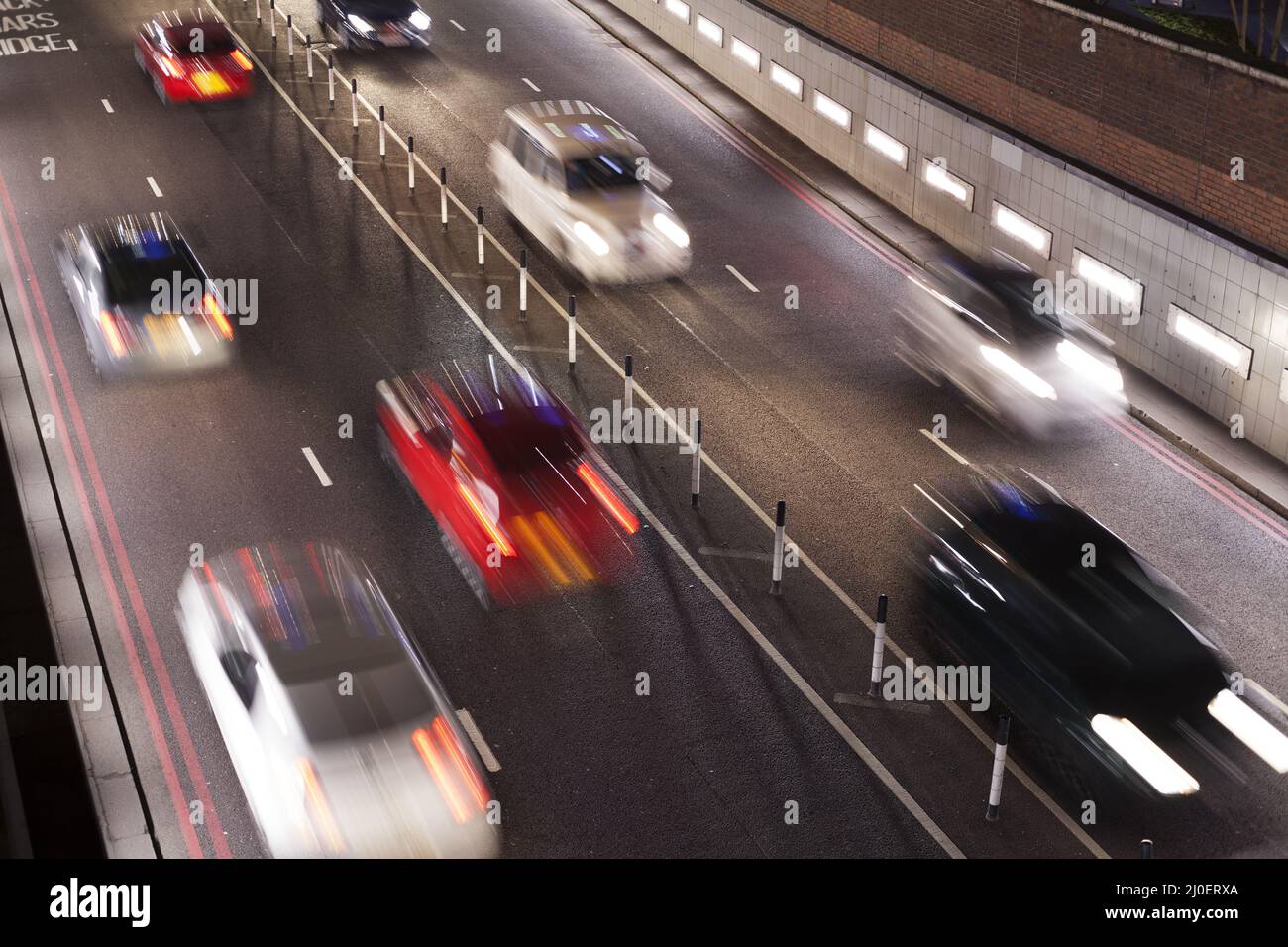 Elevated view timelapse of traffic going through an underpass at night Stock Photo