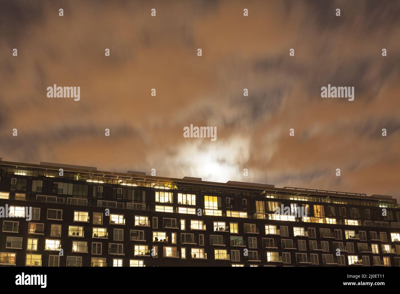 A modern apartment block at night Stock Photo