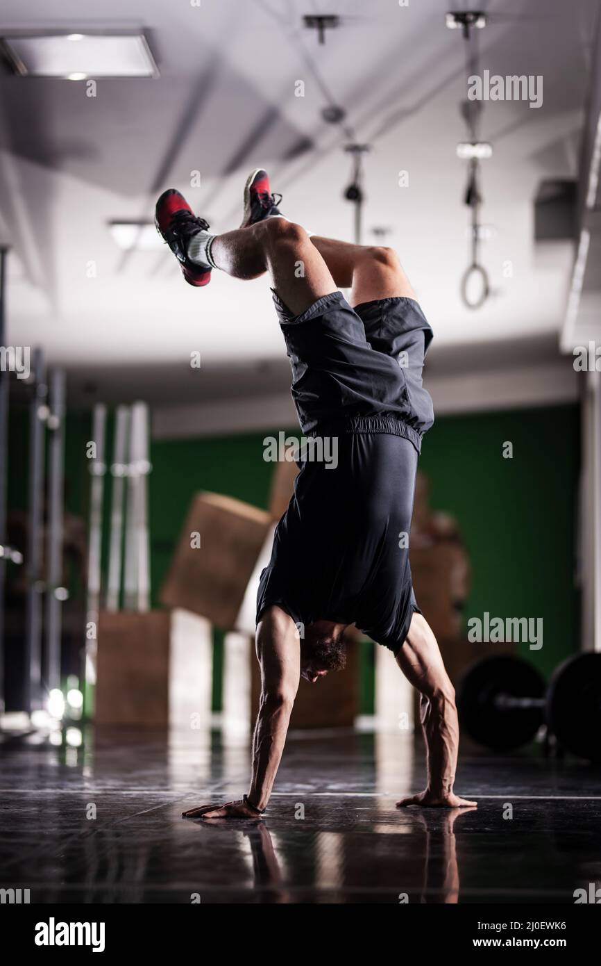 Muscular athlete standing and walking on hands upside down Stock Photo ...