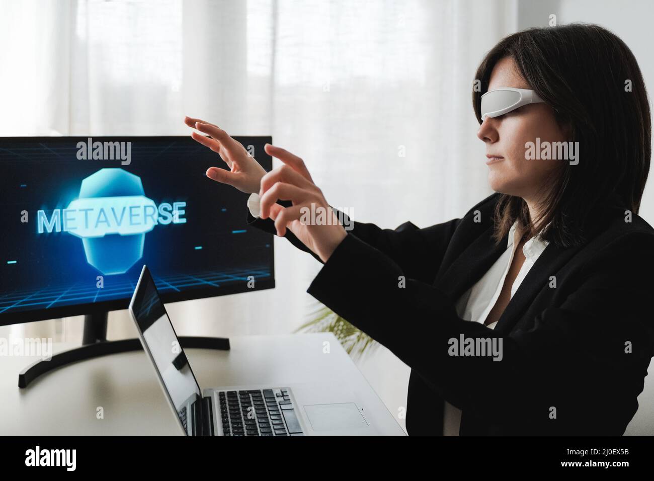 Business woman working with augmented reality goggles - Metaverse technology concept - Focus on face Stock Photo