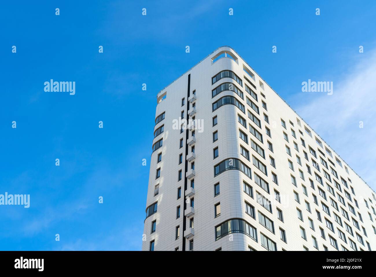 Tall white modern house. Urban architecture on a bright summer day. Stock Photo