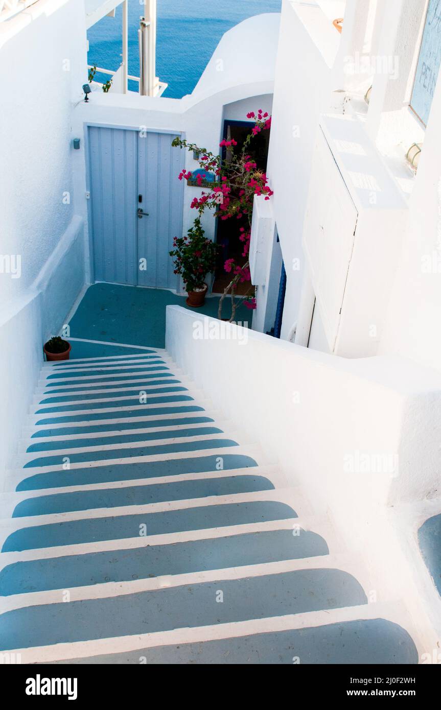 Traditional narrow stair street leading to the sea in Oia village. Santorini Island, Greece. Stock Photo