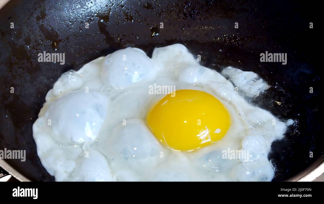 Frying and egg on a pan with oil Stock Photo