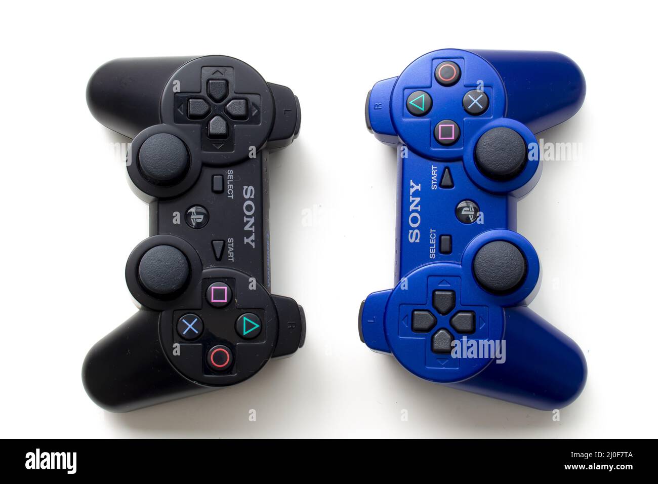 Calgary, Alberta, Canada. July 20, 2020. Black and Blue Sony Play Station control remotes on a white background Stock Photo