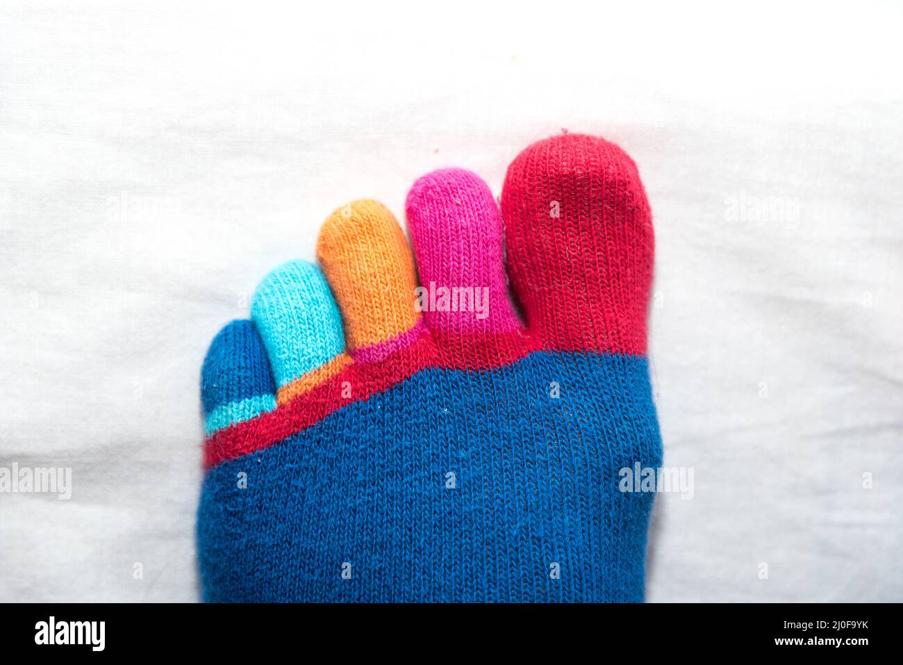 Funny colorful toes of hand-knitted sock - close-up Stock Photo