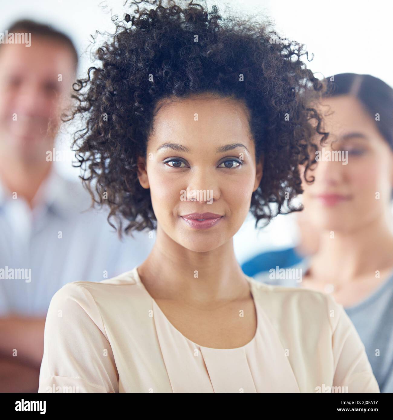 Shes a confident leader. Portrait of a beautiful woman with her colleagues in the background. Stock Photo