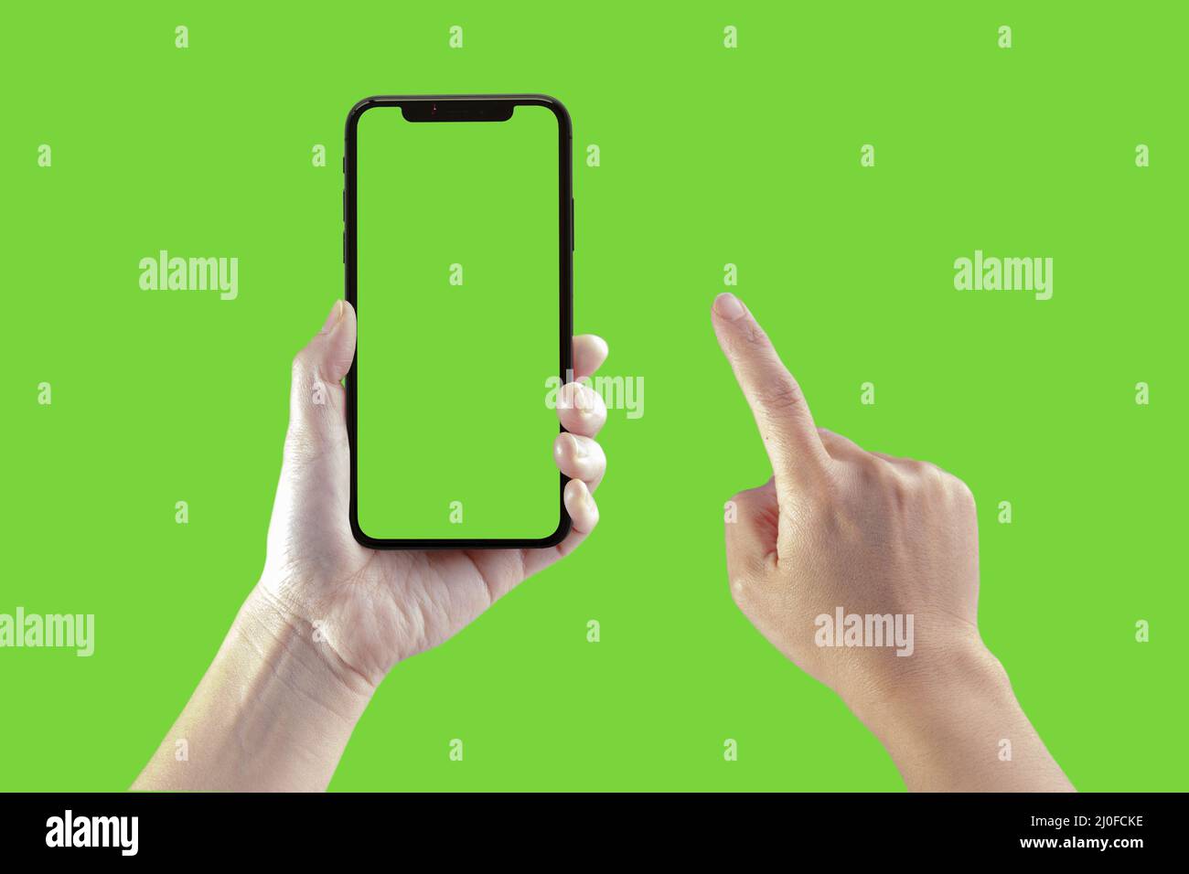 A Black Smart phone hold by a person on a green screen Stock Photo