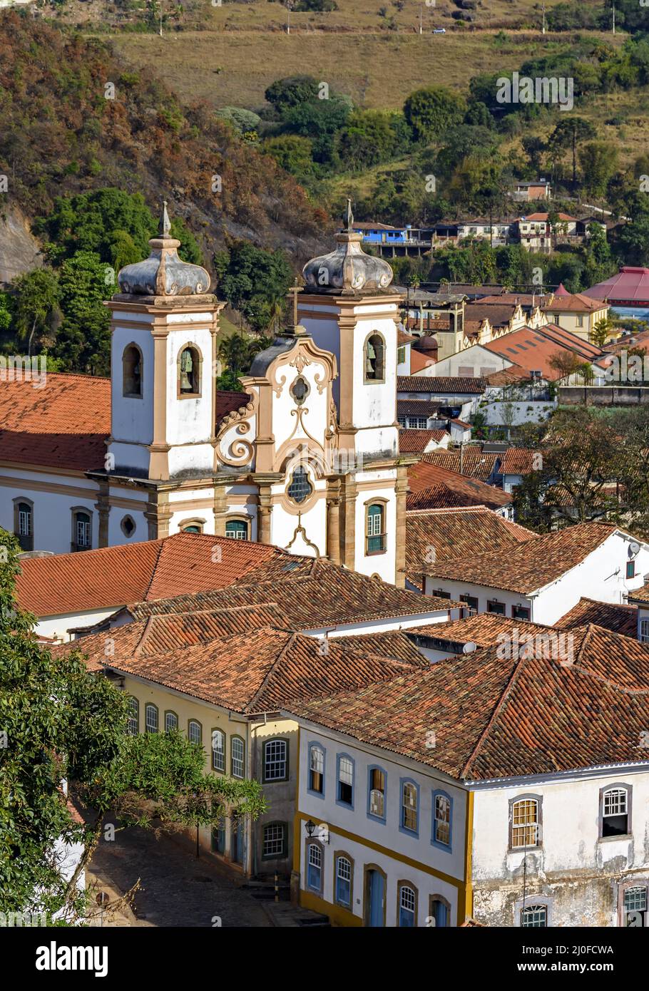 Historic church in baroque and colonial style from the 18th century amid the houses and roofs Stock Photo