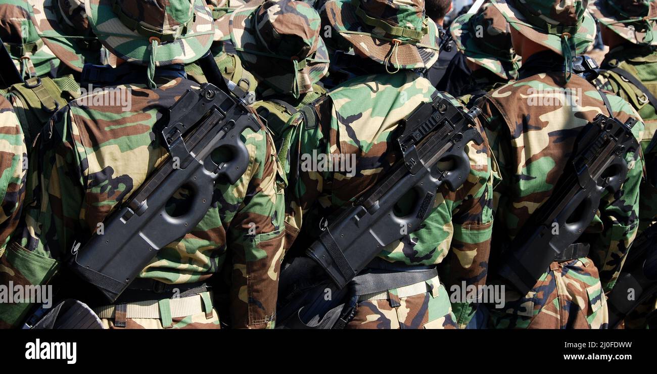 Military soldiers parading in uniform and armed with guns Stock Photo