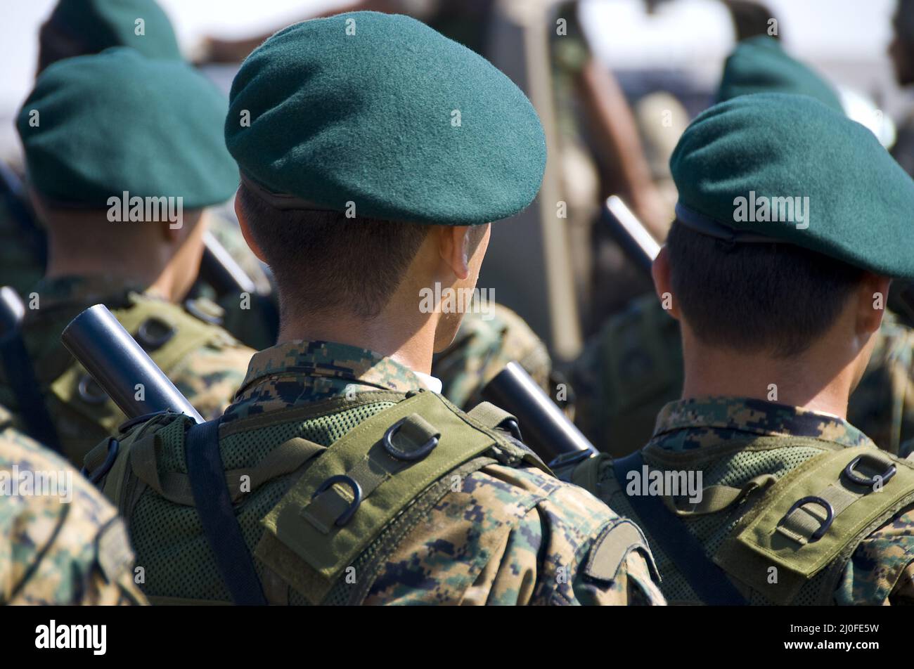 Military soldiers parading in uniform and armed with guns Stock Photo
