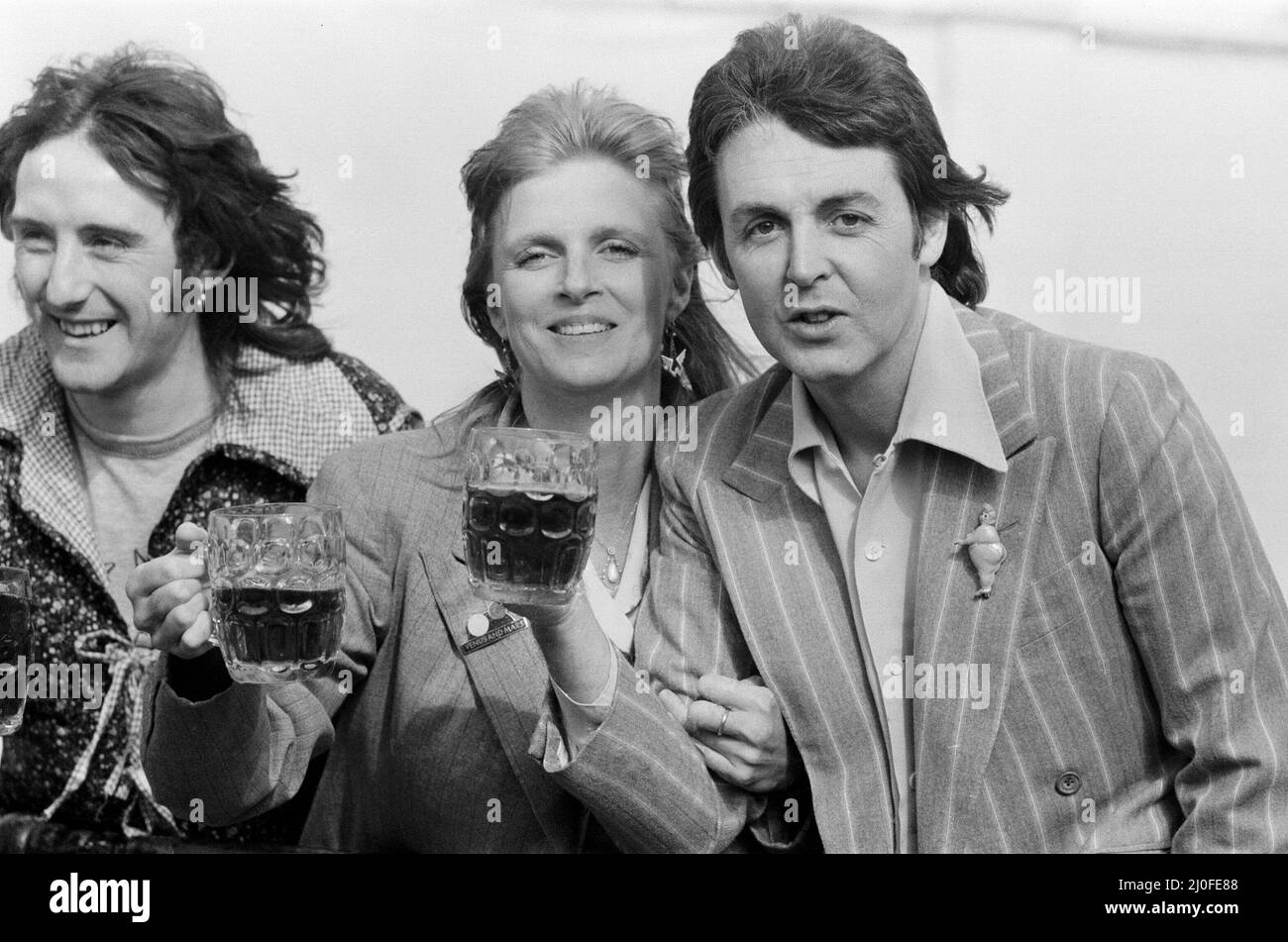 Paul McCartney and his wife Linda of pop group Wings enjoy a pint of ale as  they make a film to promote their new single "With A Little Luck" in  London. Left