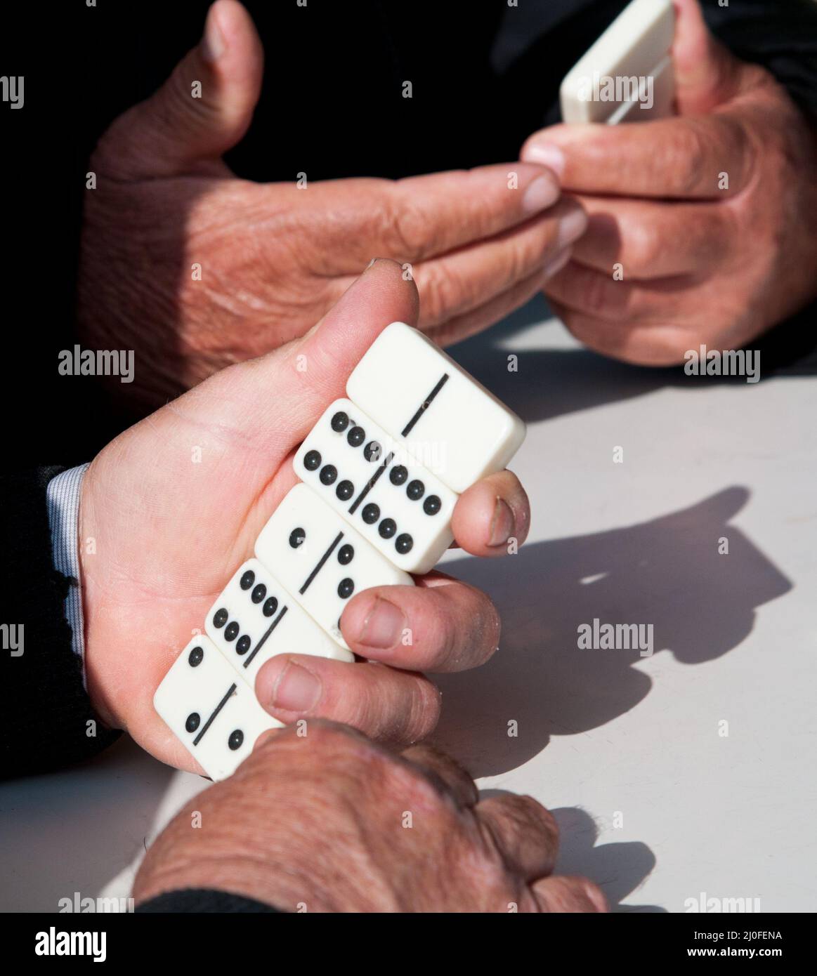 Mature retiree adults playing domino game for leisure Stock Photo