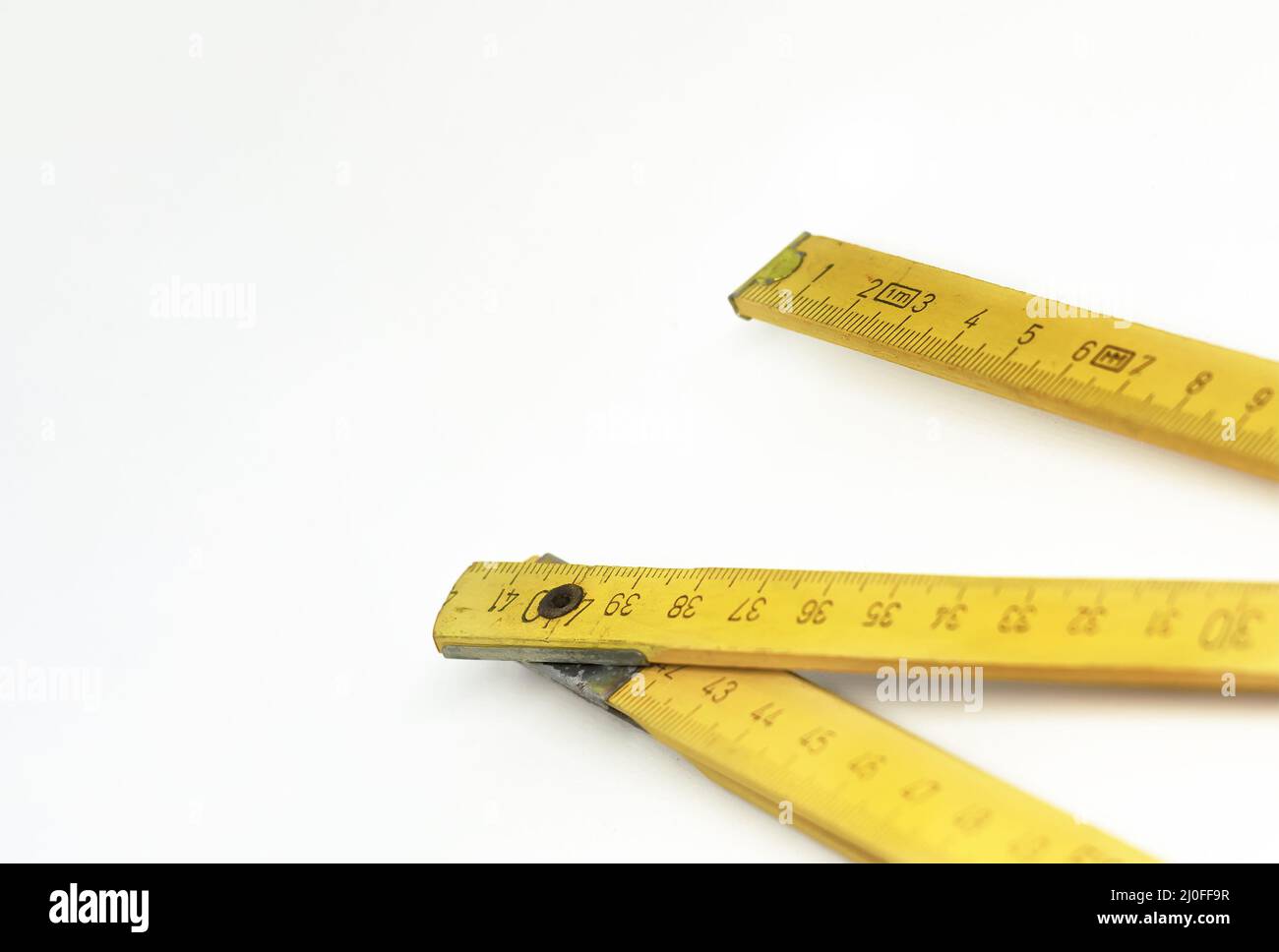 A yellow wooden folding ruler isolated on a white background Stock ...