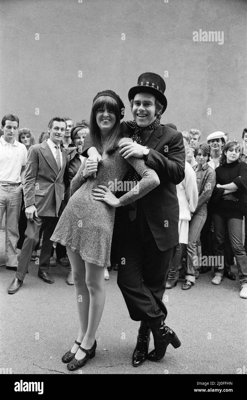 Wearing a top hat, Elton John, at a small studio in Ladbroke Grove to make a promotional film for his new single. Giving the film the feeling of the 1960's in the style of 'Ready Steady Go', Elton invited Cathy McGowan to take part. 5th October 1978. Stock Photo