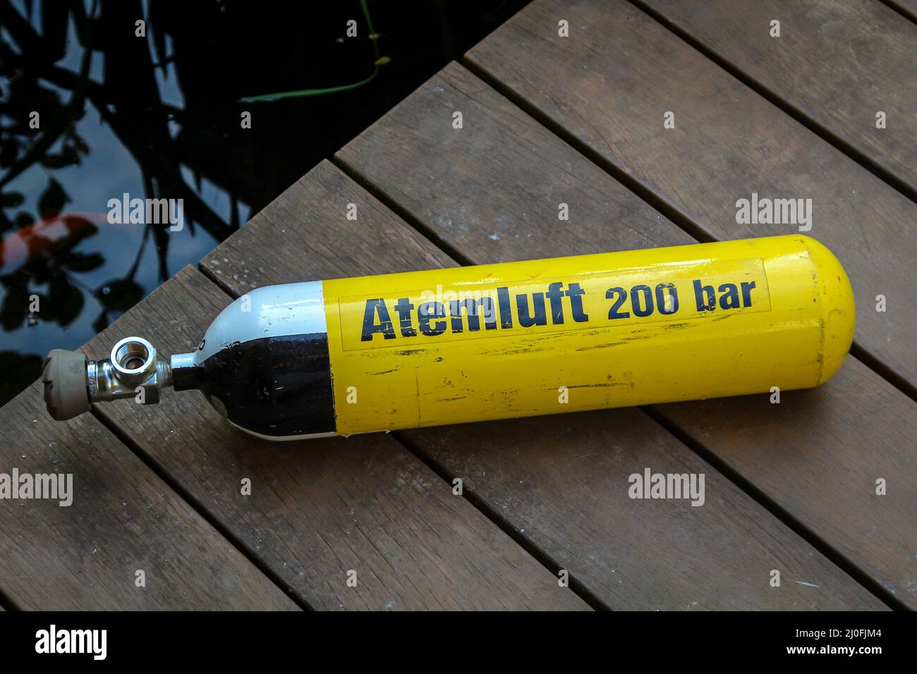 A diving bottle with breathing air lies on the landing stage. Stock Photo