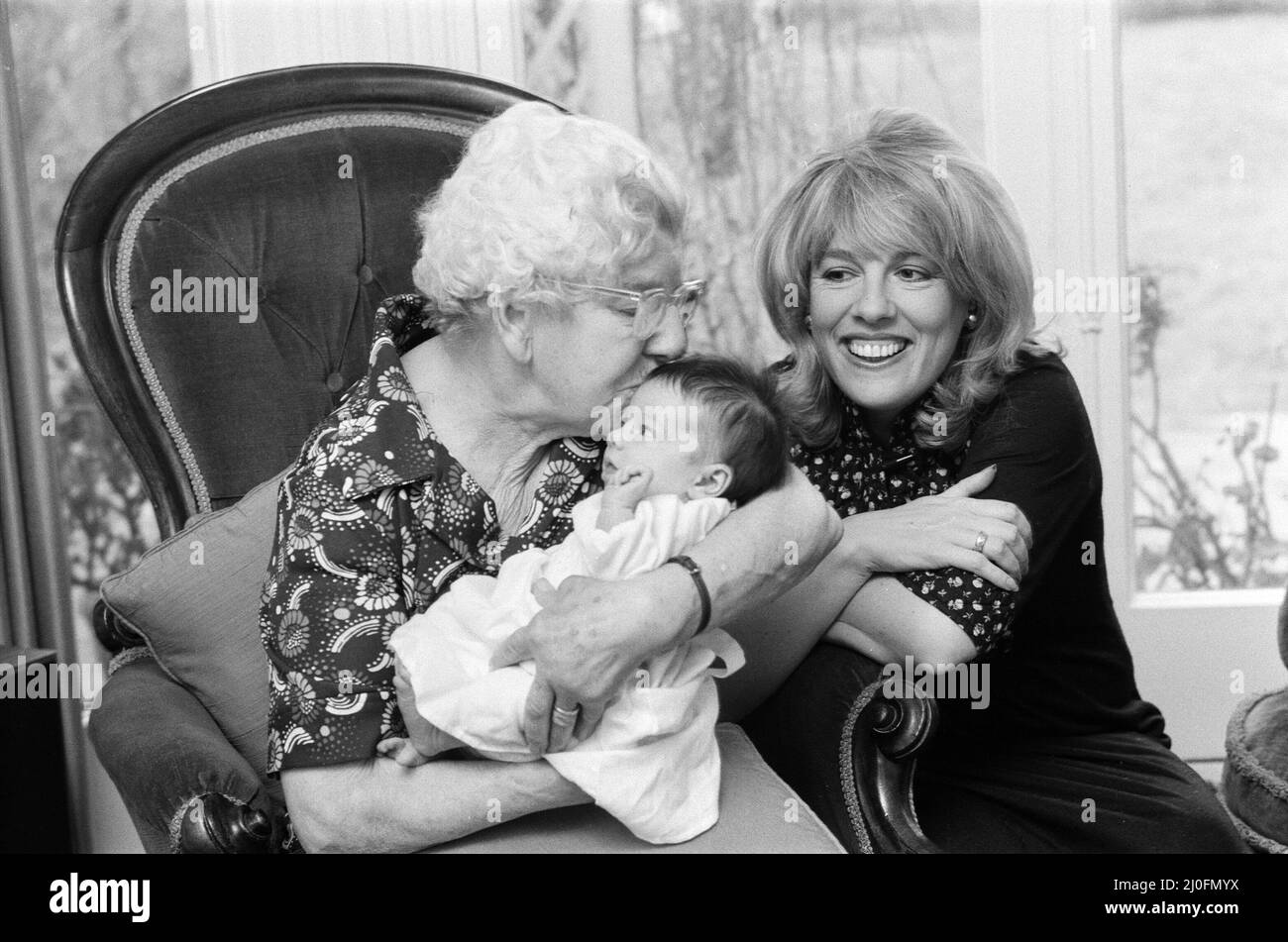 'That's Life' presenter Esther Rantzen presents her month old baby Emily to Annie Mizen today. Annie, 86, who became famous on That's Life by eating caviar and Chinese food, testing drinks and dancing in the street, was invited to elevenses at Esther's home and to meet Emily. 22nd February 1978. Stock Photo