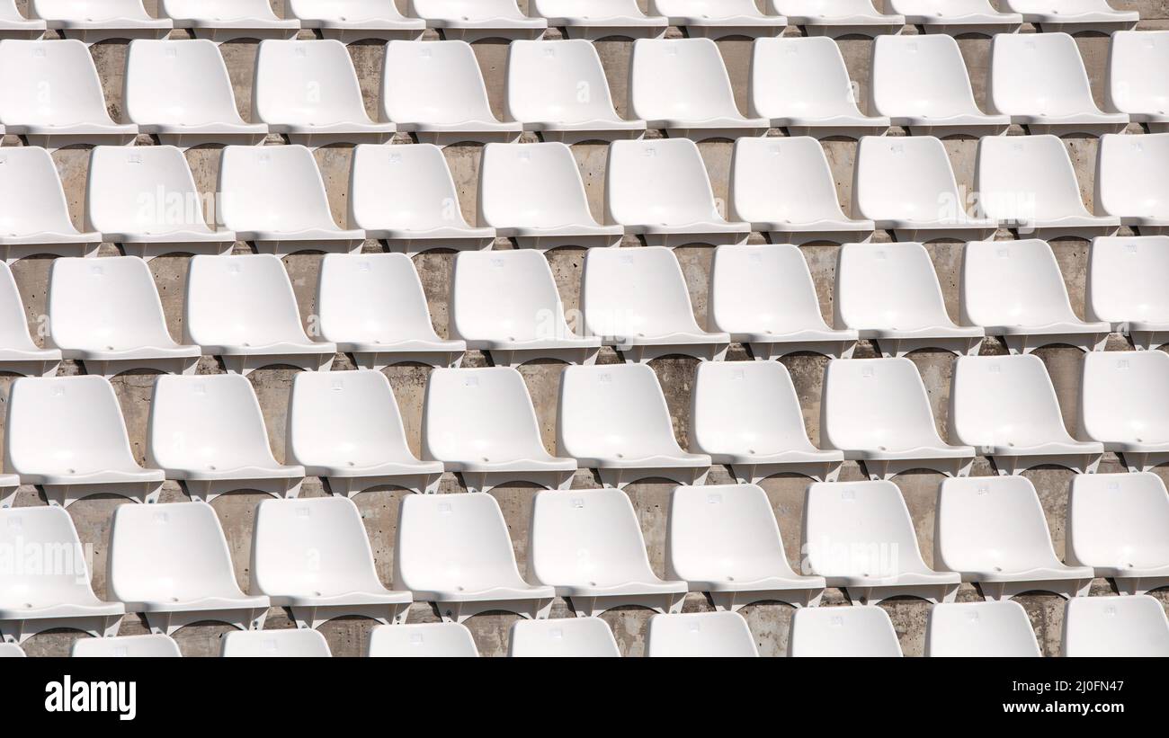Empty white stadium chairs in a row Stock Photo