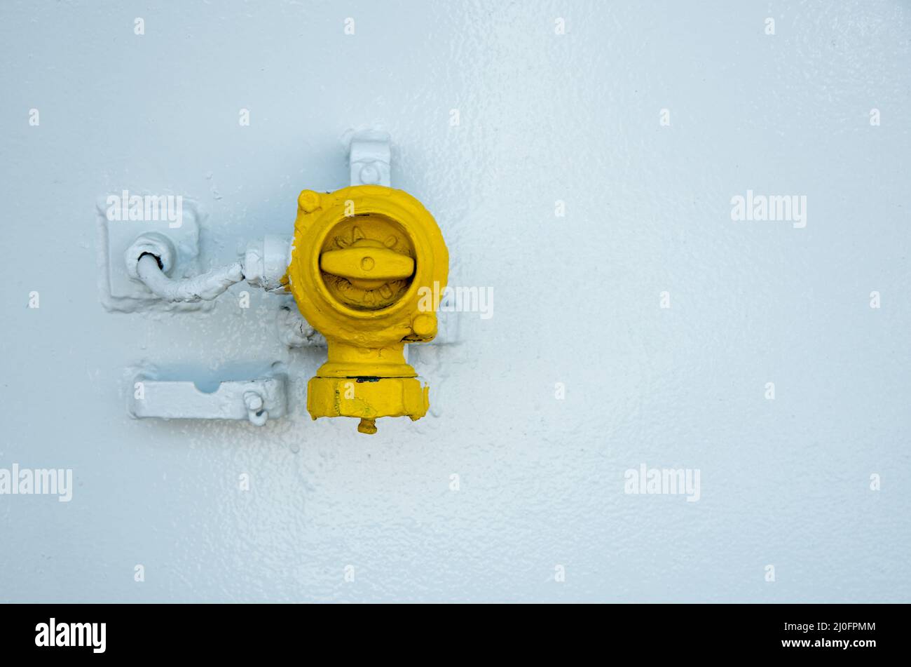 Yellow control  industrial switch on a white metallic surface Stock Photo
