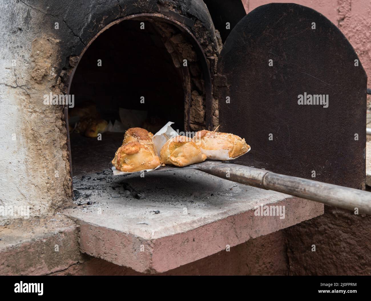 Cooked Cypriot Easter cheese pies Flaounes on a clay oven . Cyprus Stock Photo