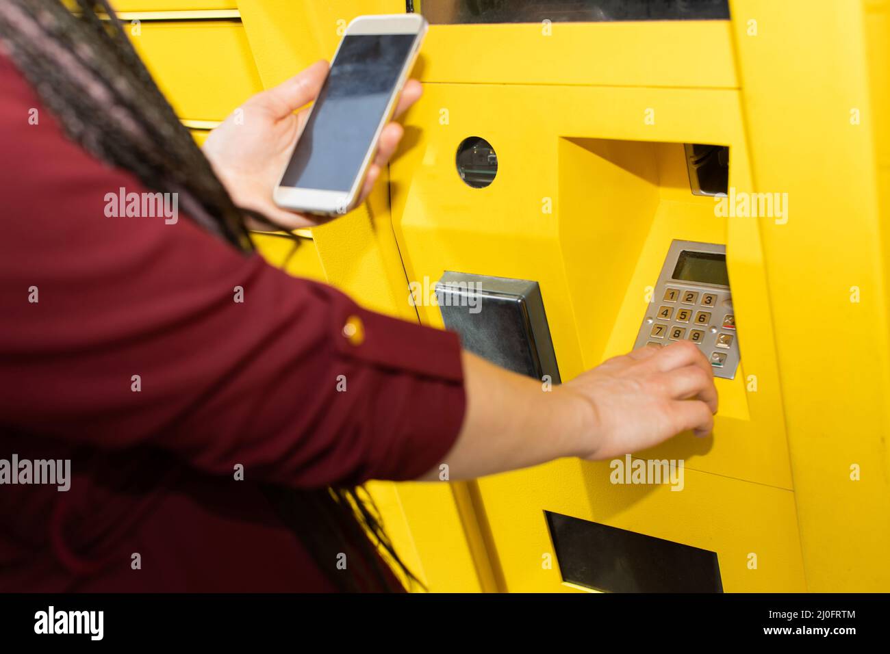 The girl enters the numeric pickup code for the parcel into the parcel ...