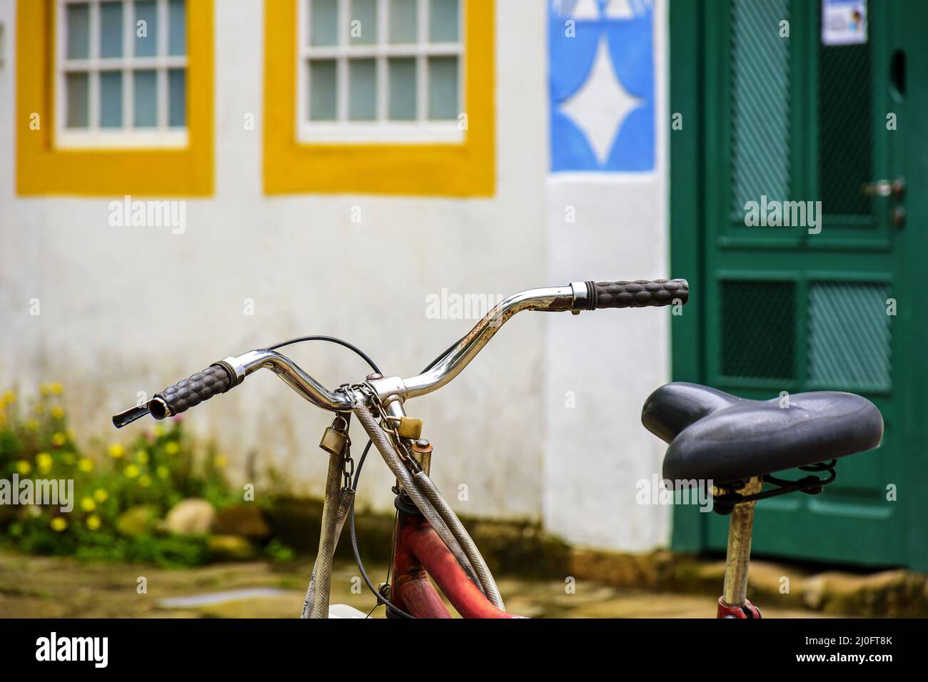Old bicycle stopped in front of the colonial style houses Stock Photo