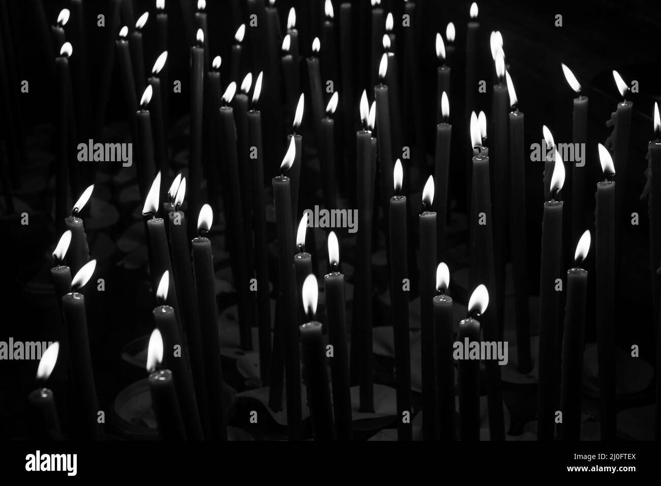 Burning wax candles in the temple black and white photo Stock Photo