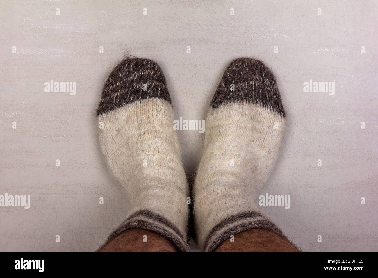 Men's feet in white knitted wool socks close-up Stock Photo
