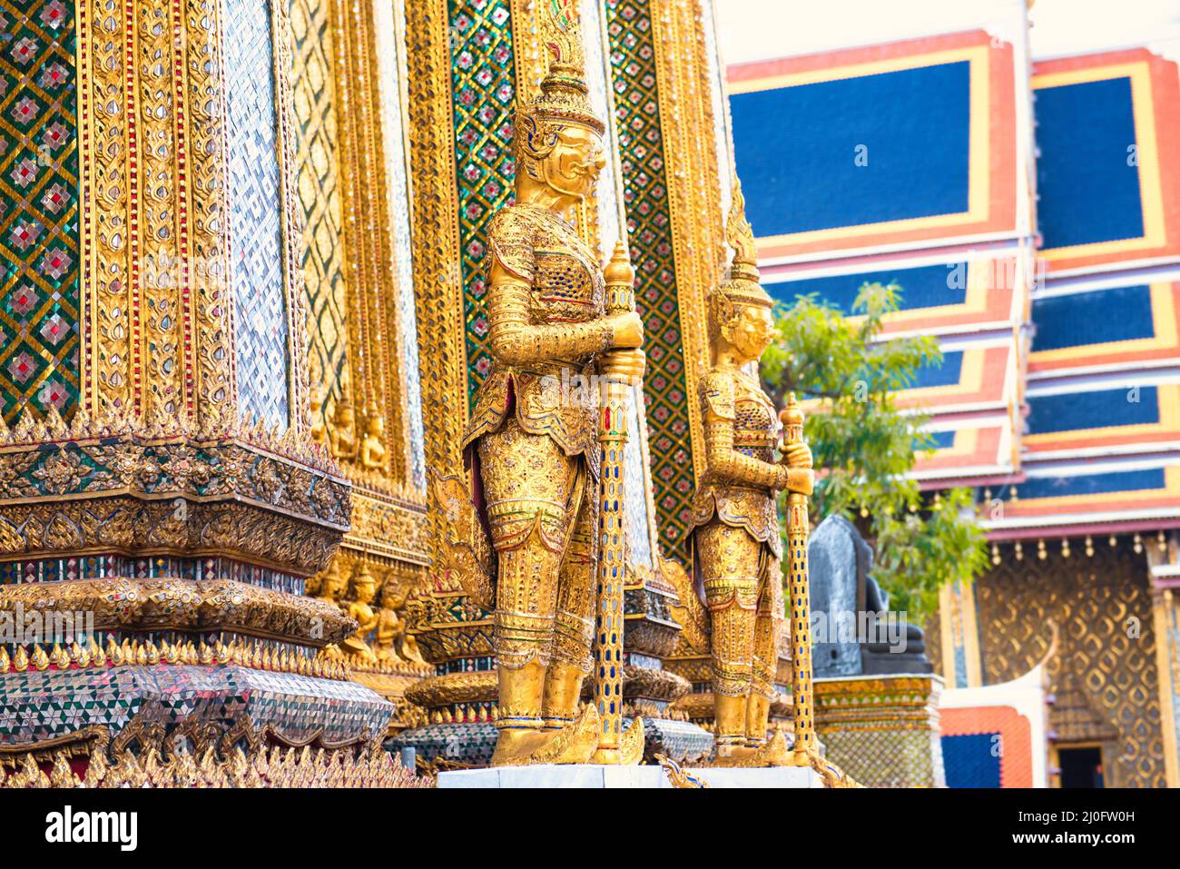 Gold statues at entrance to Temple of Emerald Buddha in Bangkok Stock Photo