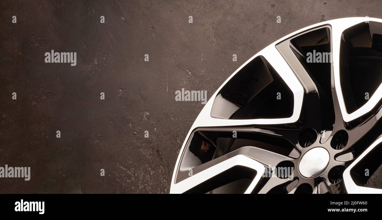 new stylish cool alloy wheel on the tire dark textured background ...