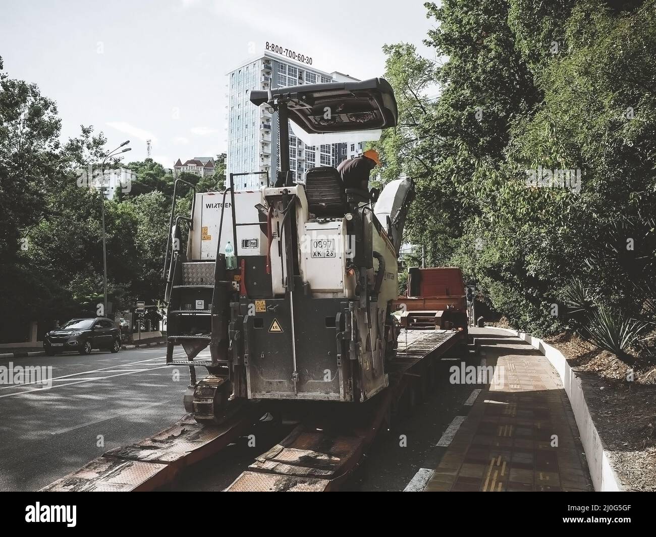 Russia, Sochi 05.07.2020. Road milling machine and truck are working on the road in the city Stock Photo