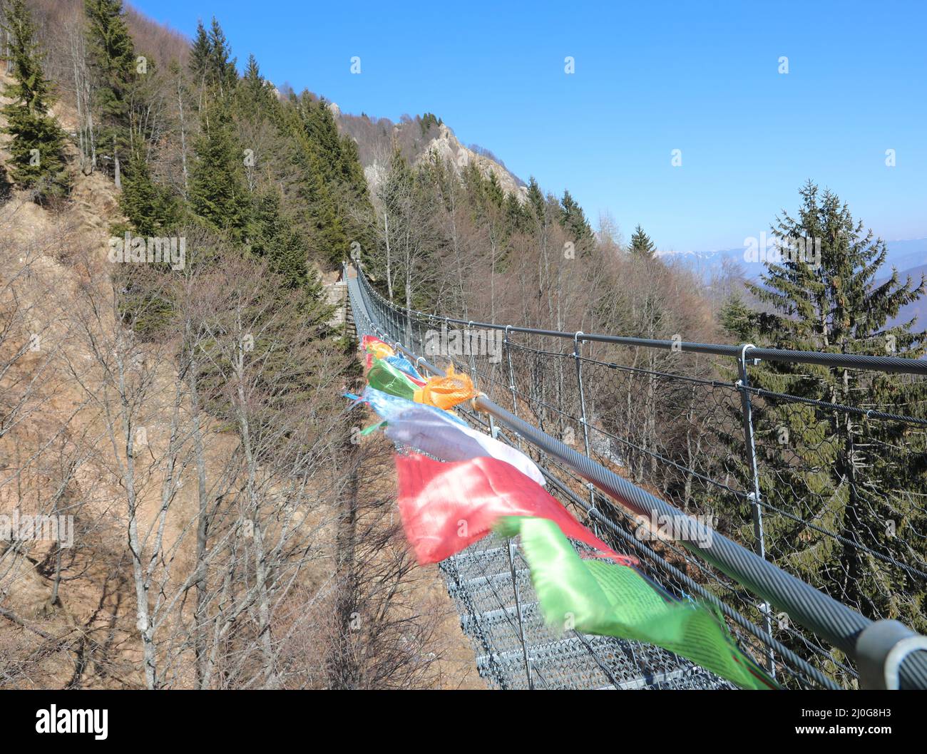 Colorful Tibetan flags symbol of brotherhood peace and prayer on the long Tibetan suspension bridge made with steel ropes without people Stock Photo