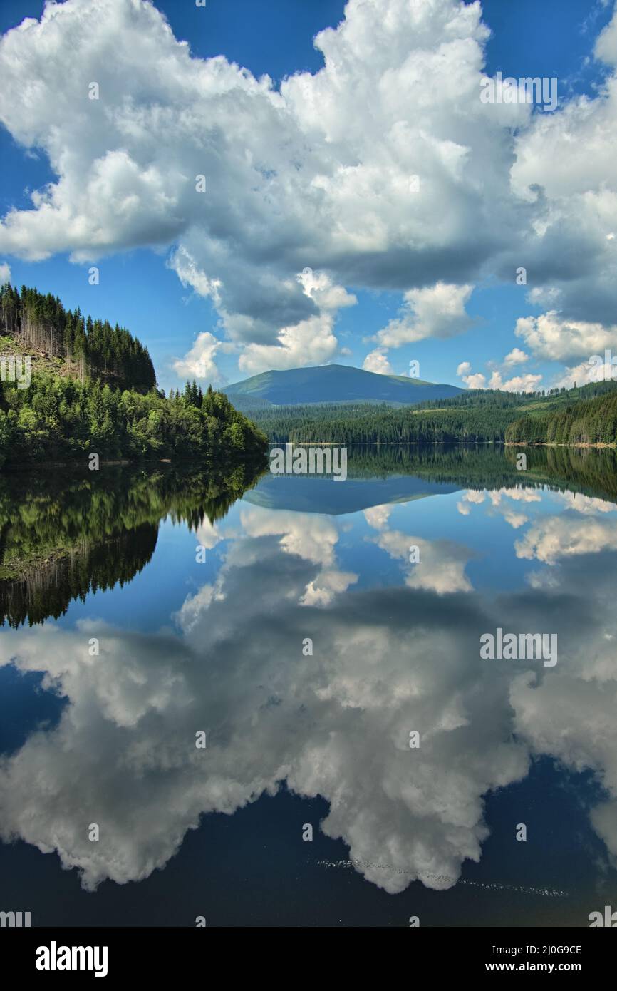 water reflection on lake of white clouds in blue sky of Romania Stock Photo